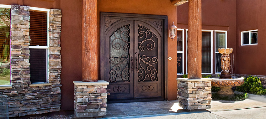 facade of a home with antique french iron entry doors 