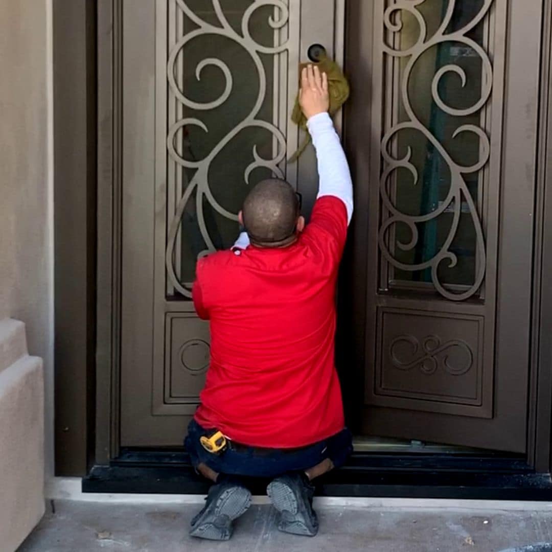 First Impression Ironworks Employee professionally cleaning an iron entry door