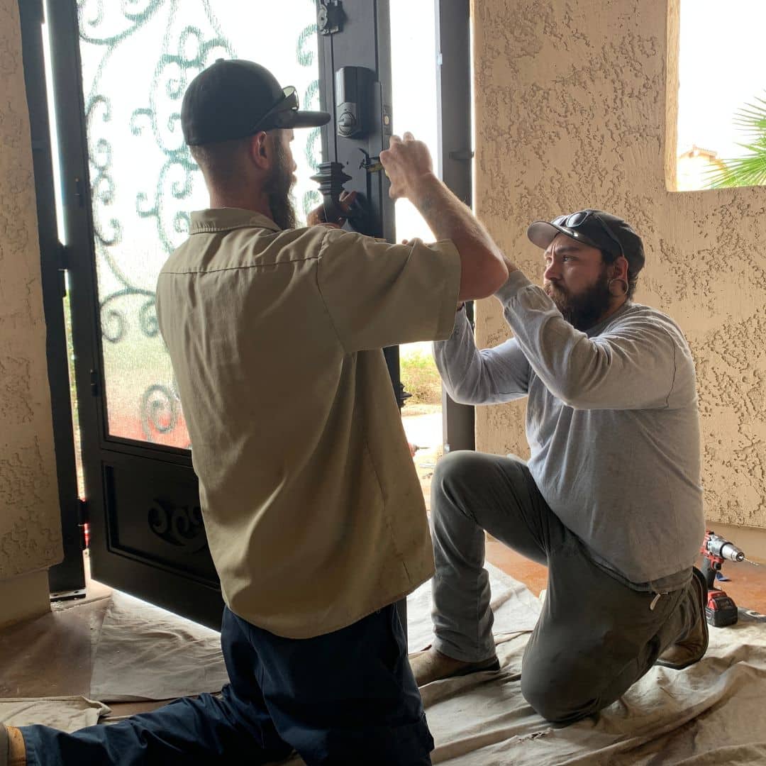 Two First Impression Ironworks employees checking the parts on an iron entry door