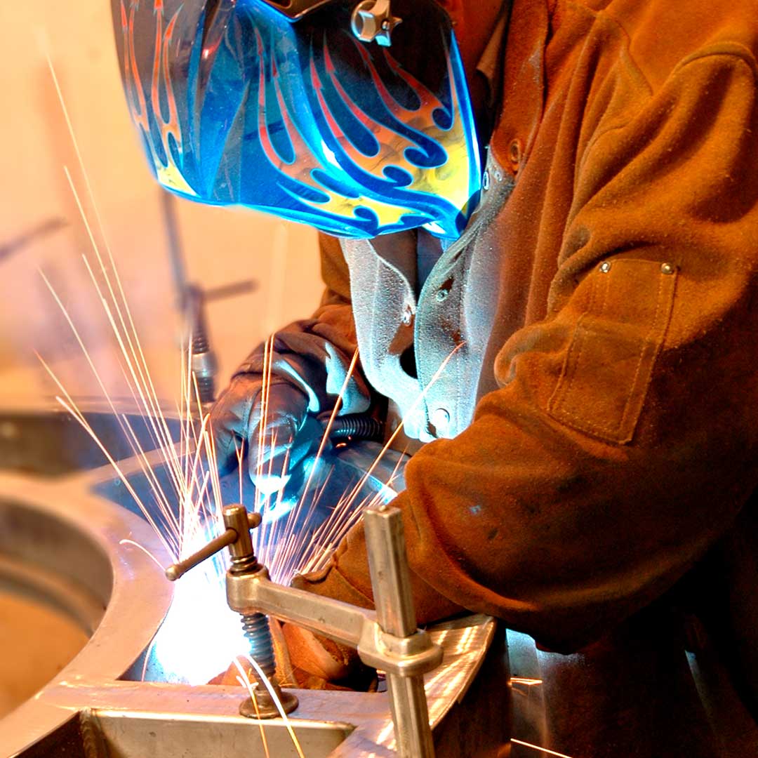 A welder working on a First Impression Ironworks Iron Entry Door