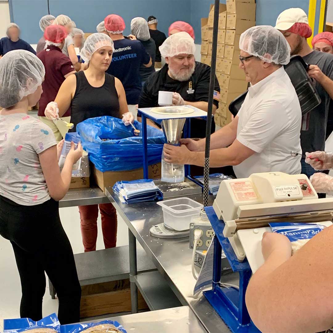 First Impressions Ironworks Employees Preparing Meals at Feed My Starving Children