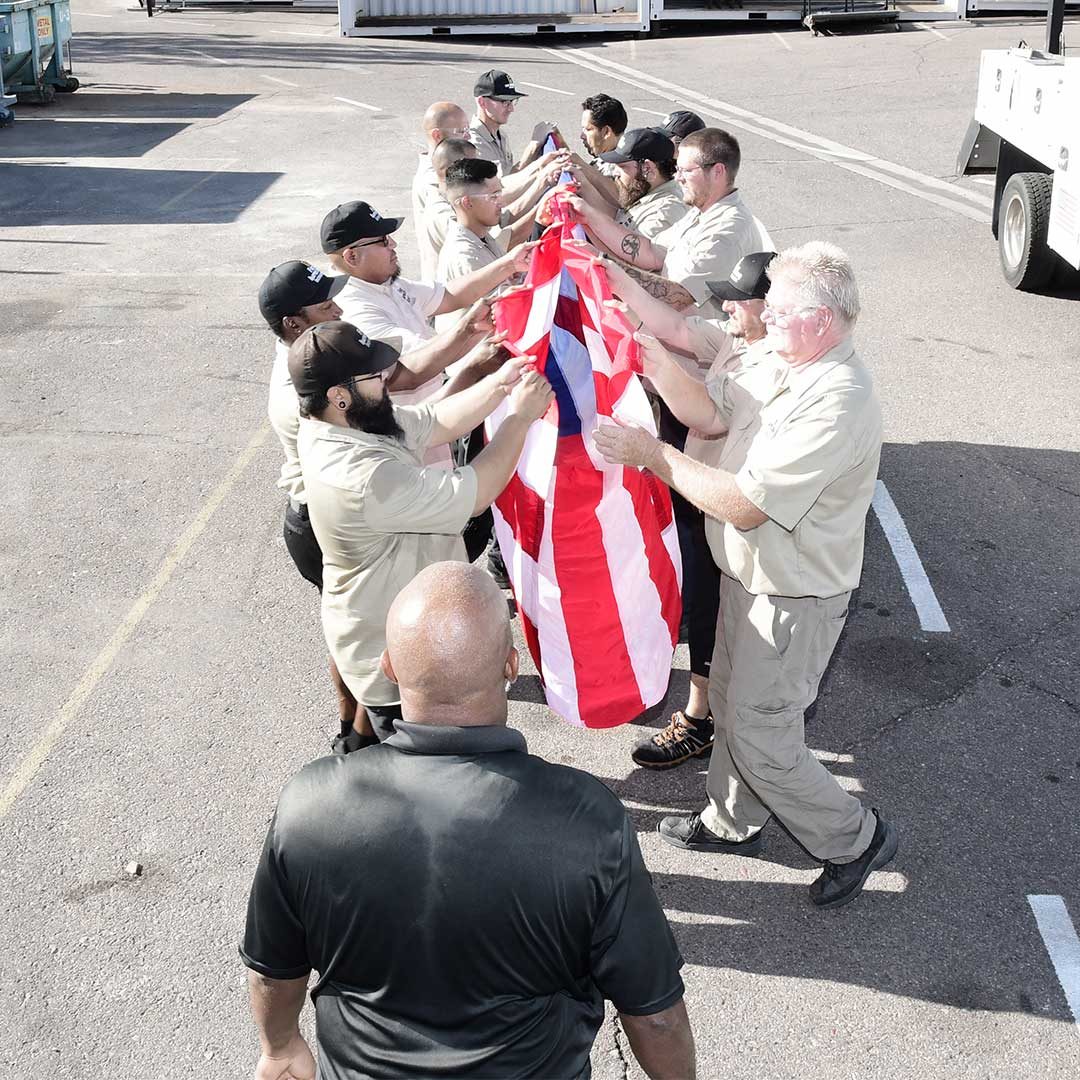 First Impression Ironworks Employees Folding A Large Flag