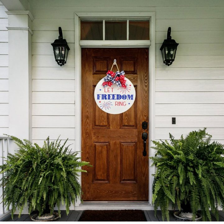 Door hanger with the words "Let freedom ring" hanging on a front door
