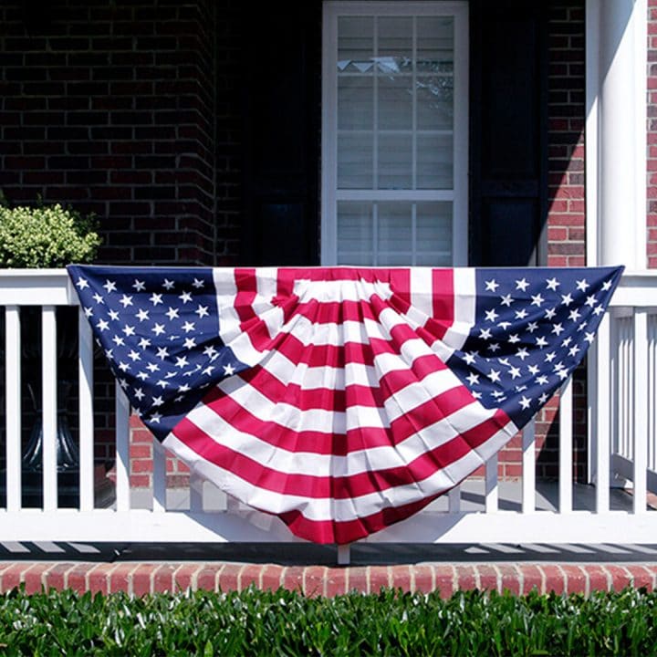 Patriotic bunting hanging from white front porch railing.  Our doors can be delivered nationwide. 