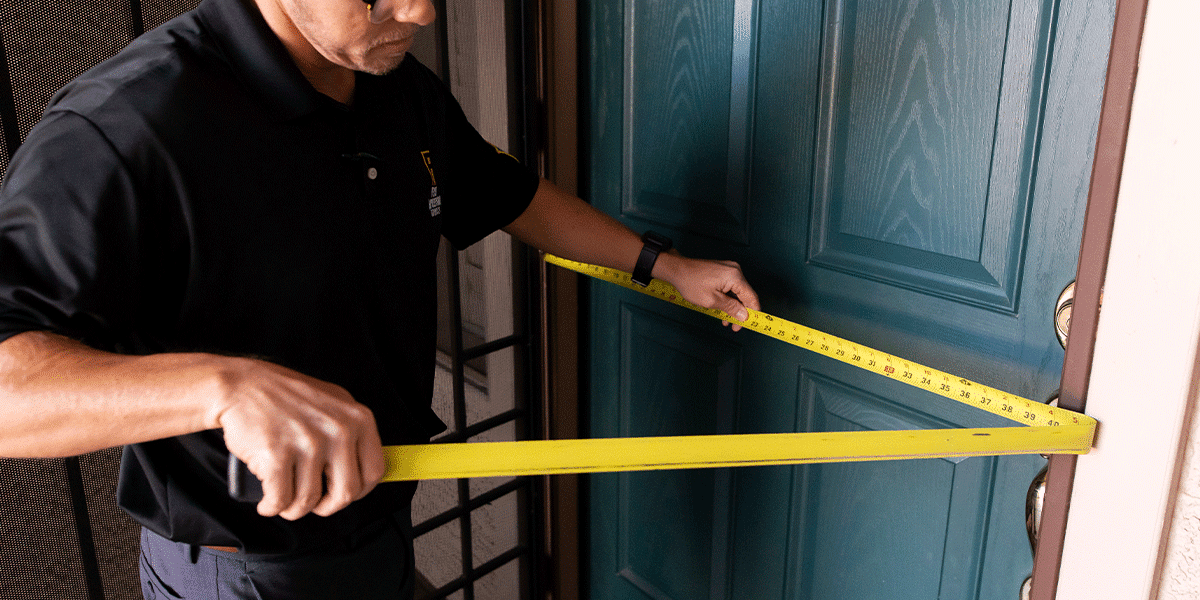 First Impression Ironworks employee measuring for a new custom iron security door