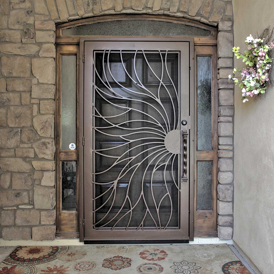 First Impression Ironworks iron security door with a sun swirl pattern and decorative iron handle