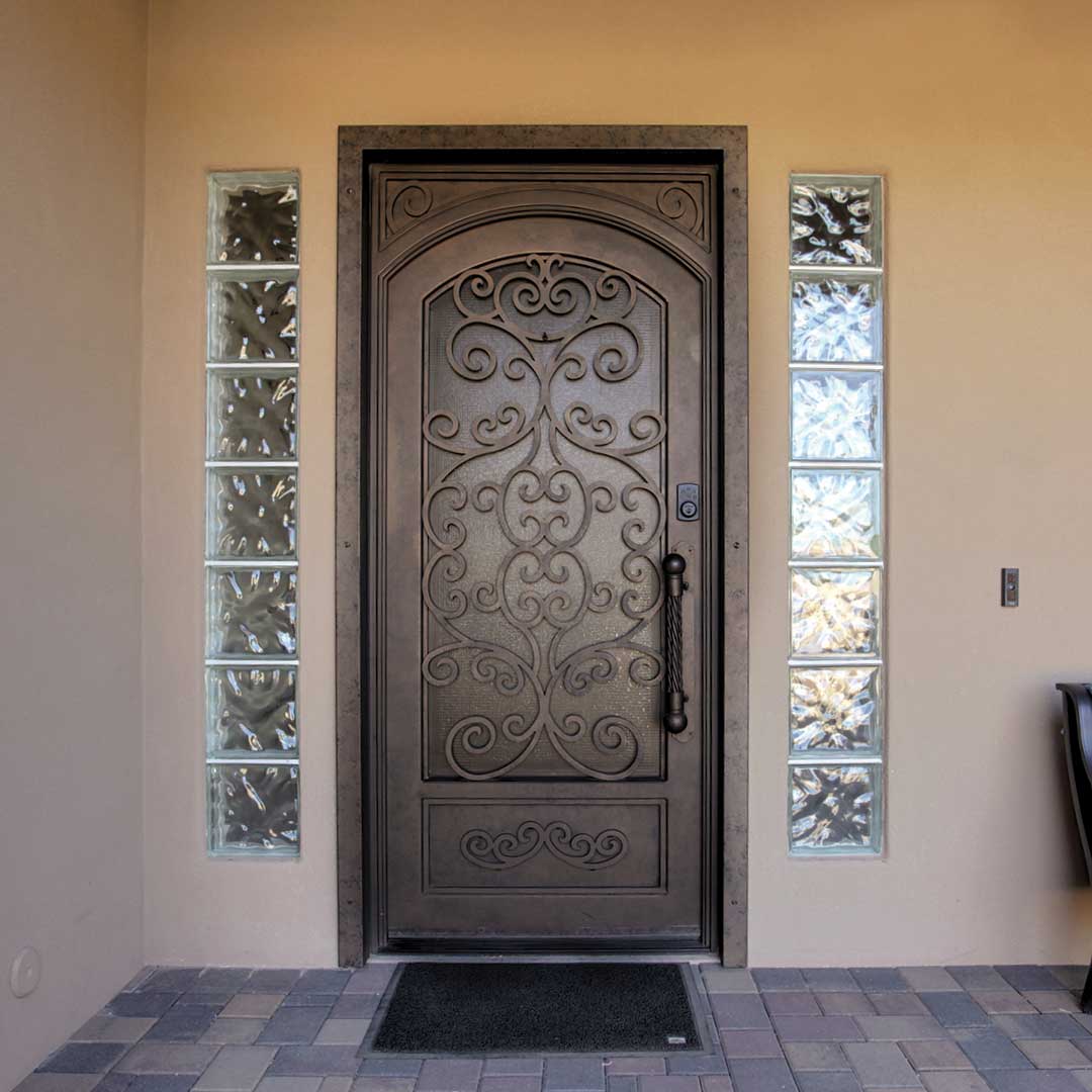 First Impression Ironworks iron and lass entry door with an intricate swirl design