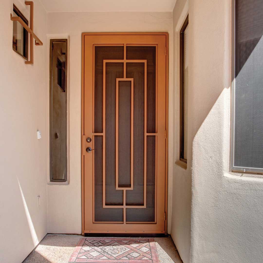 First Impression Ironworks terracotta colored iron security door with a modern design