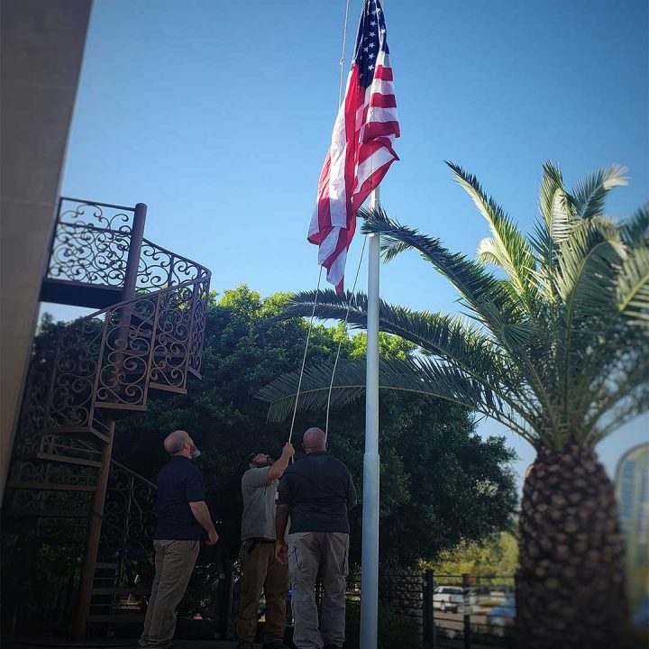 First Impression Ironworks Employees raising flag at their Gilbert showroom