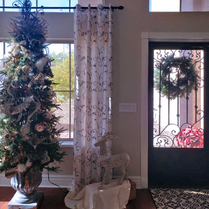 Interior view of a First Impression Ironworks security door.  Inside of the home is decorated for Christmas, including a Christmas tree.