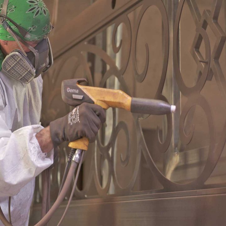 1st Impression Ironworks employee powder coating an iron door