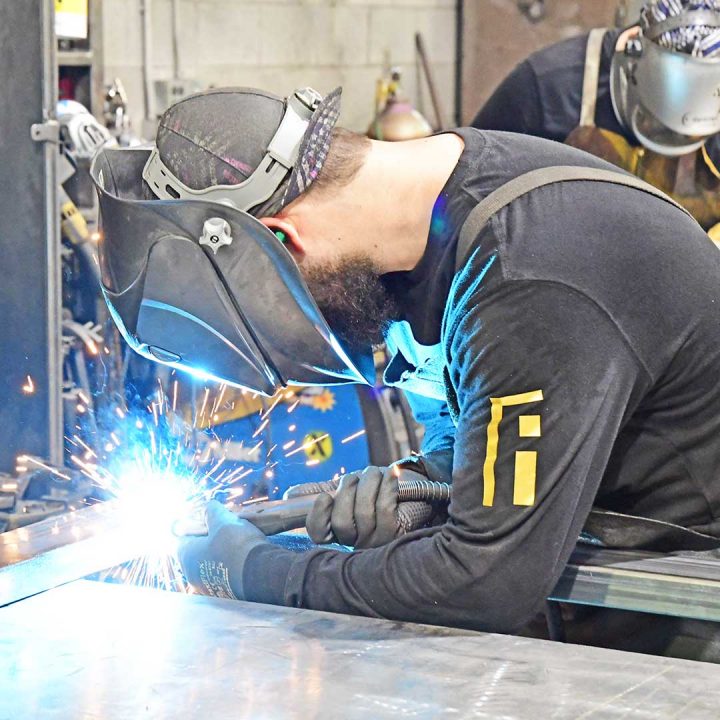 First Impression Ironworks employee welding an iron door