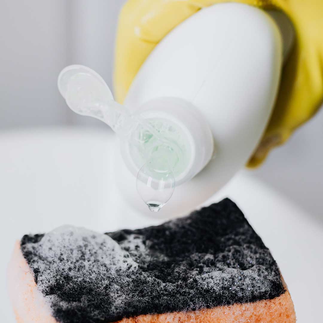 pouring dish soap onto a sponge
