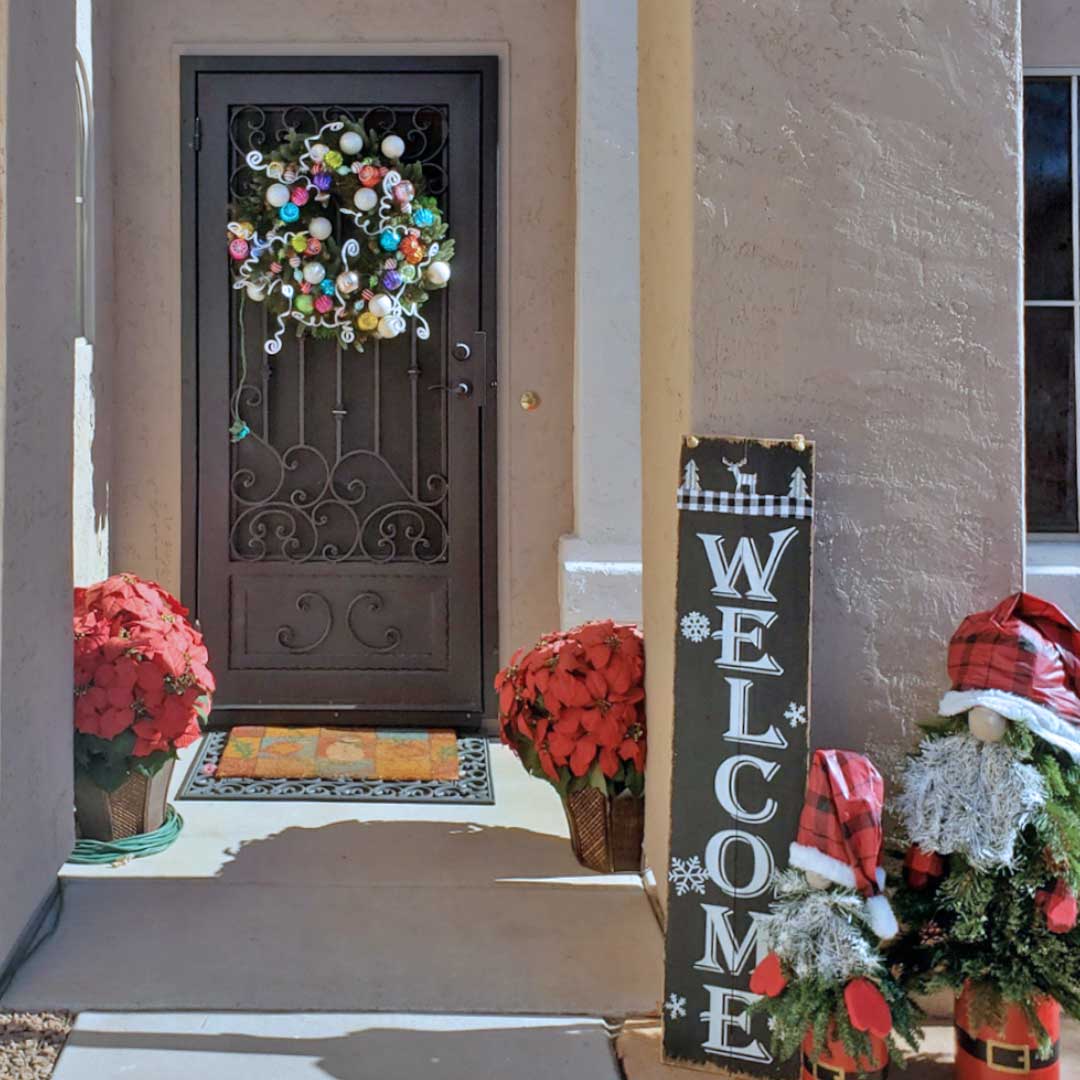 Front entry of a home with a colorful wreath hanging on the front door
