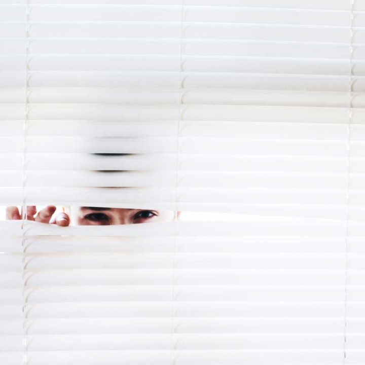 Neighbor looking through window blinds