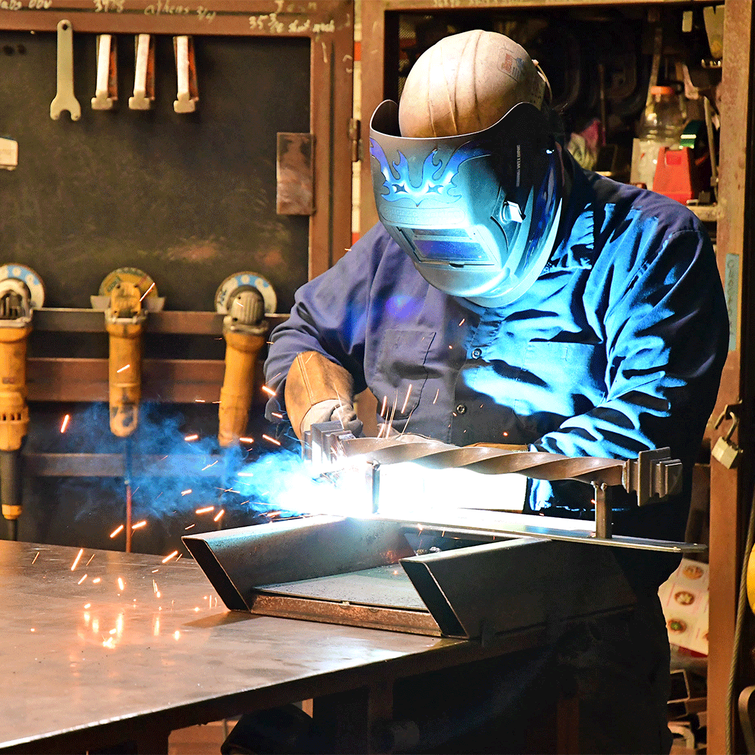 First Impression Ironworks employee welding part of an iron door