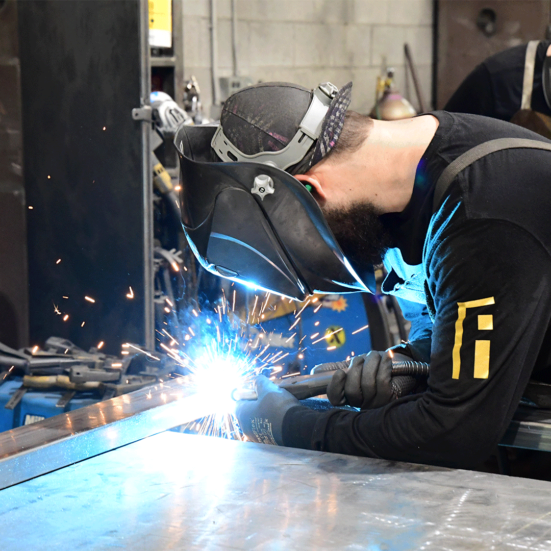 First Impression Ironworks employee welding part of an iron door