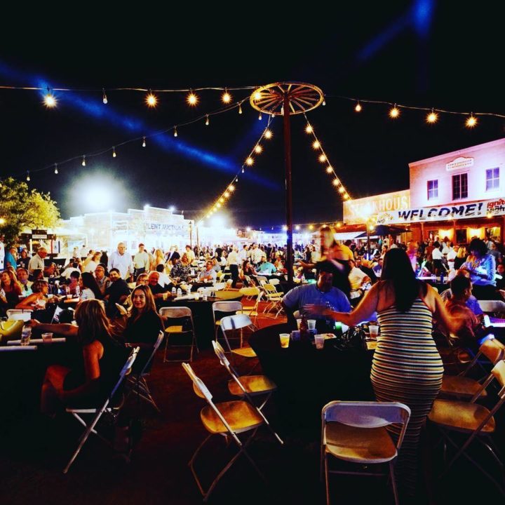 People attending the Ignite the Light Event, sitting at tables at night