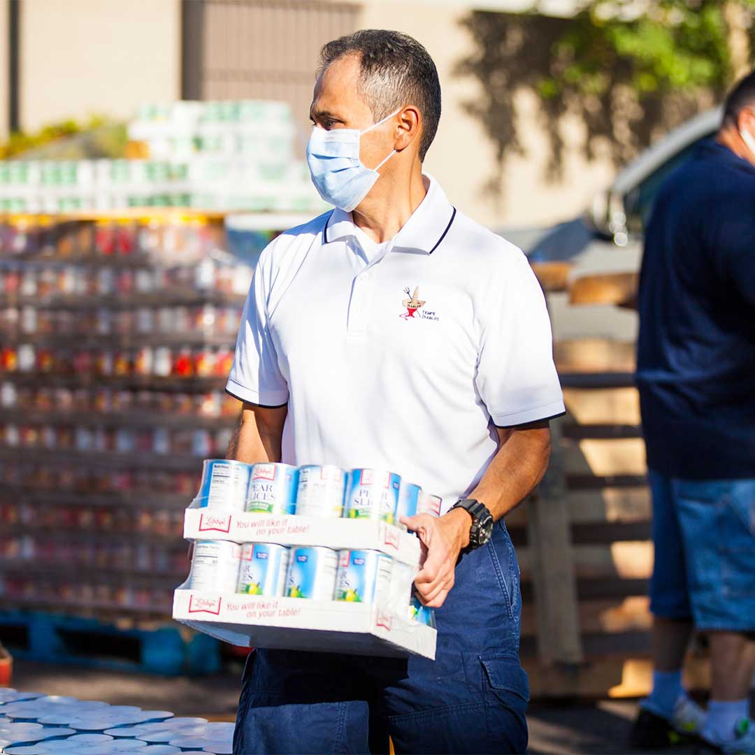 Man carrying cases of canned food