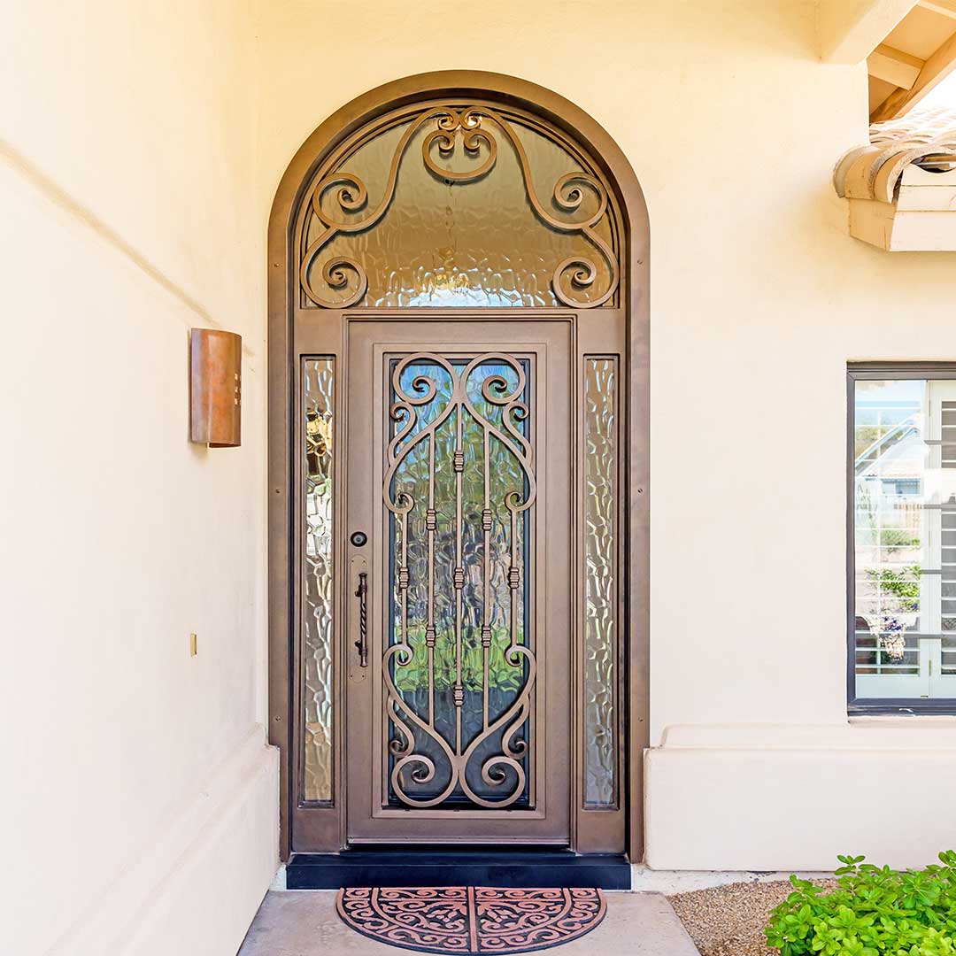 Arched iron entry door with glass and scrollwork