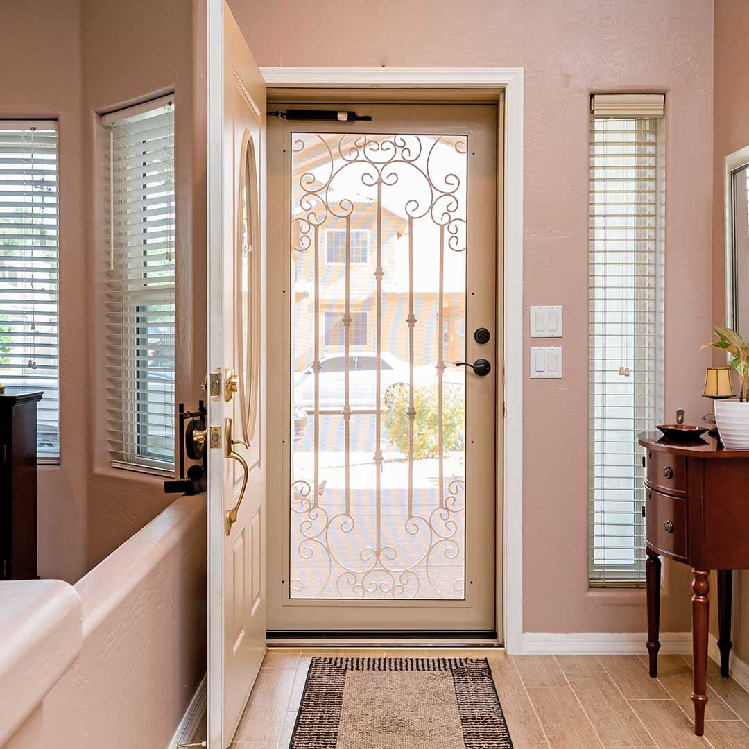 View from a foyer, looking at a open front door with a First Impression Ironworks security door