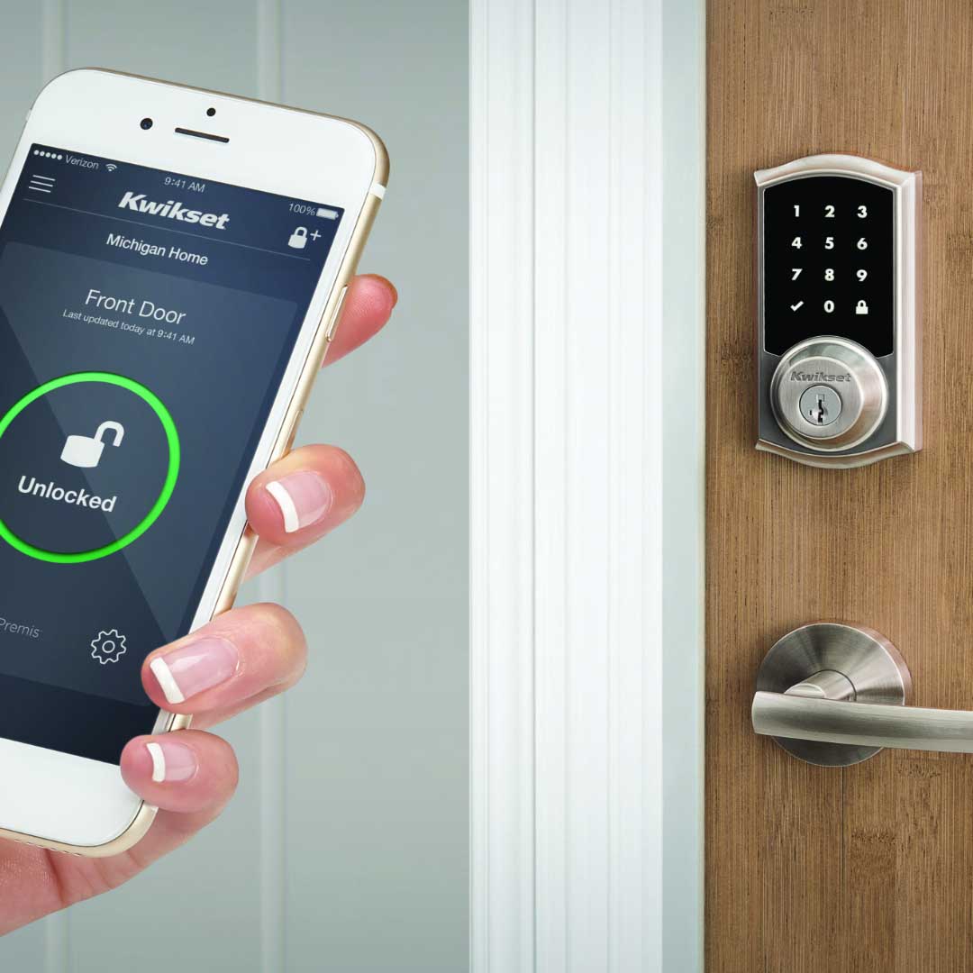 Hand holding a smart phone that is being used to open a lock on the front door of a home