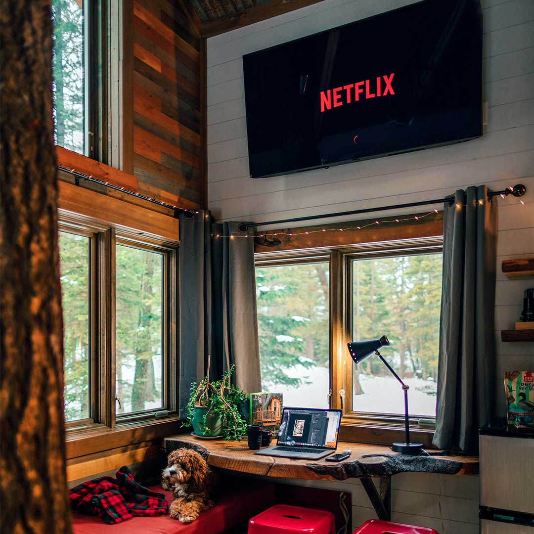Television hung over a widow with the Netflix logo on the screen