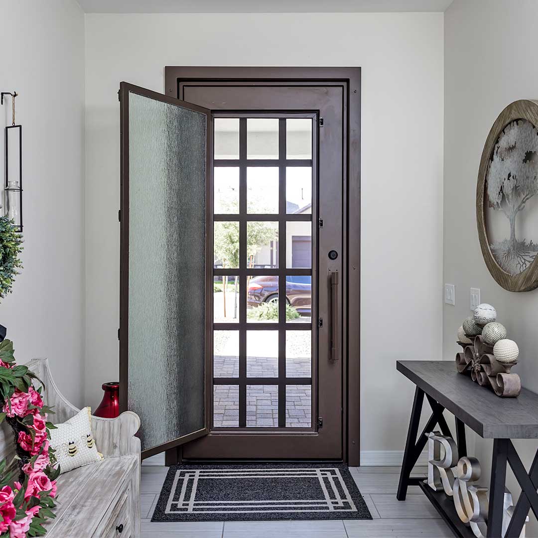 dark brown traditional iron entry door with a glass panel that is open to allow airflow