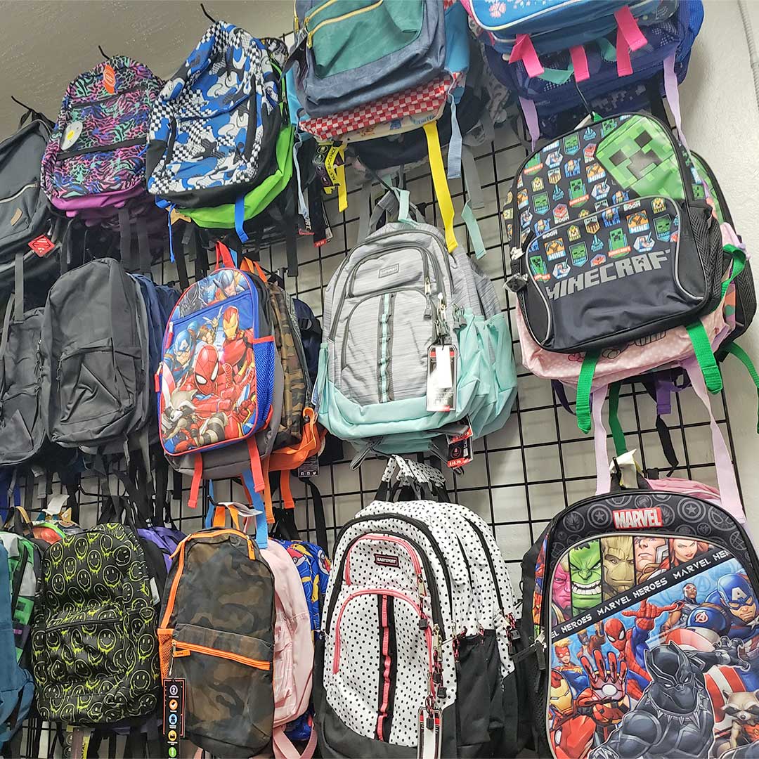 Wall of backpacks hanging on a wall at Backpacks 4 Kids AZ