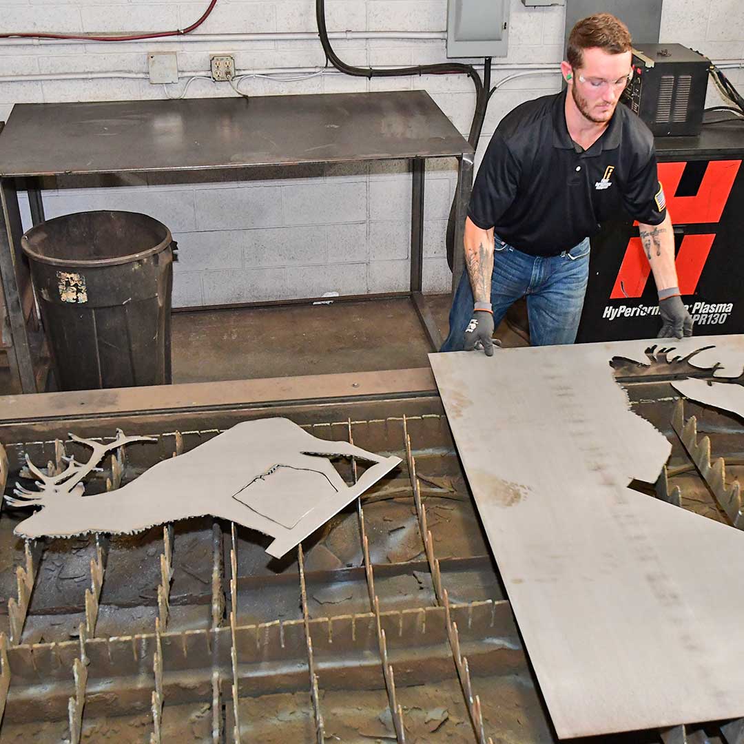 First Impression Ironworks employee removing plasma cut iron artwork