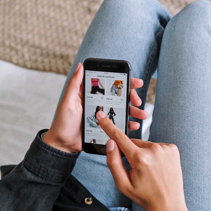 hand holding a mobile phone with a shopping website displayed on the screen