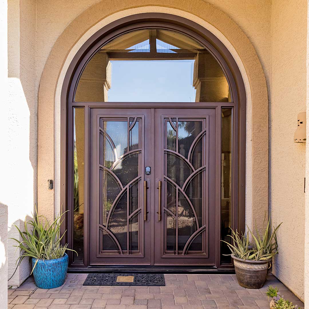 Large First Impression Ironworks iron and glass iron entry doors with larch arched window over the doors