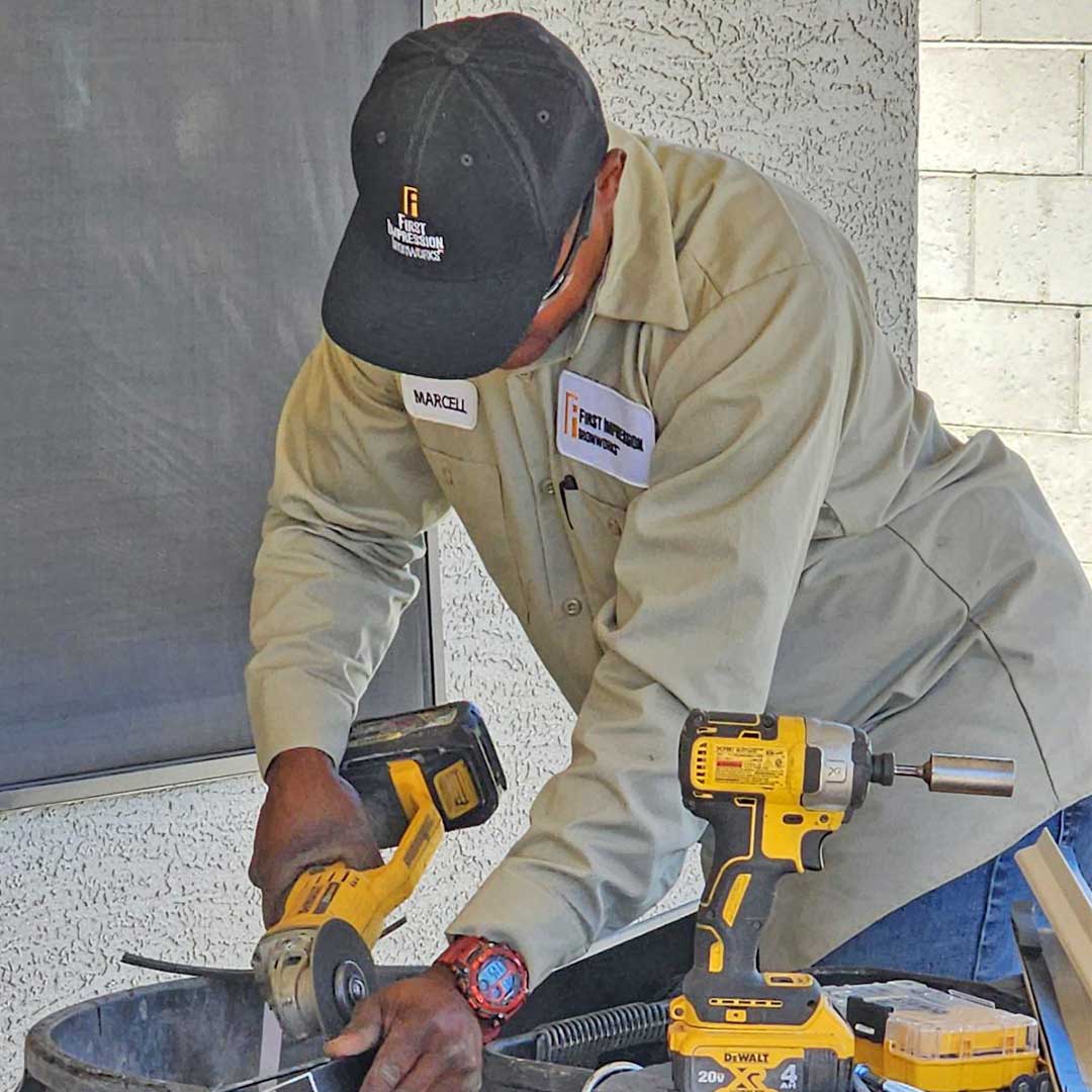 First Impression Ironworks volunteer cutting with a saw