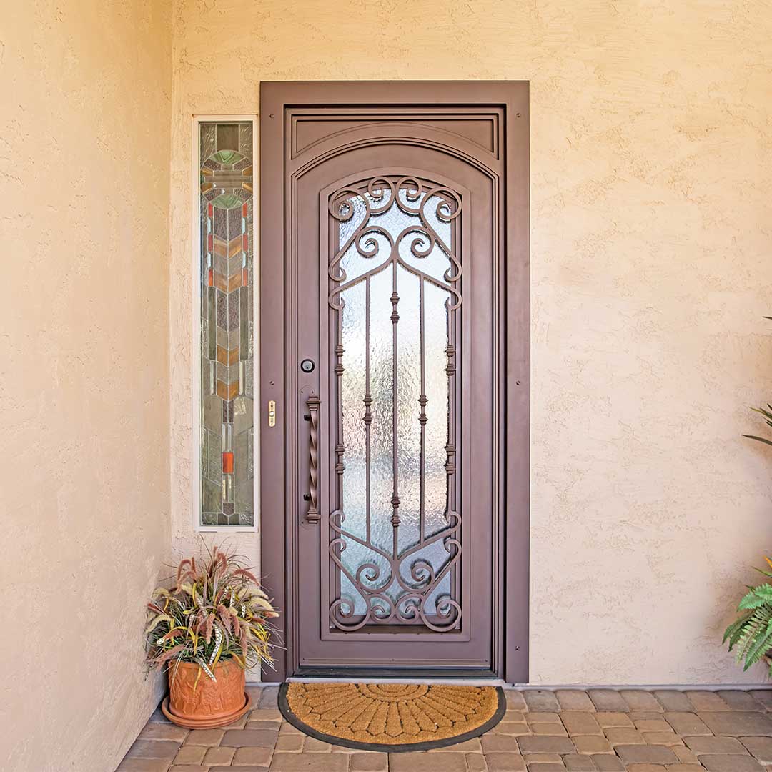 First Impression Ironworks French Tip Door with scrolled details and a glass panel