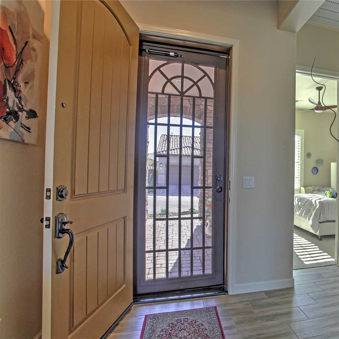First Impression Ironworks  iron security door shown from the inside, with the interior wooden door open, allowing airflow through the home.