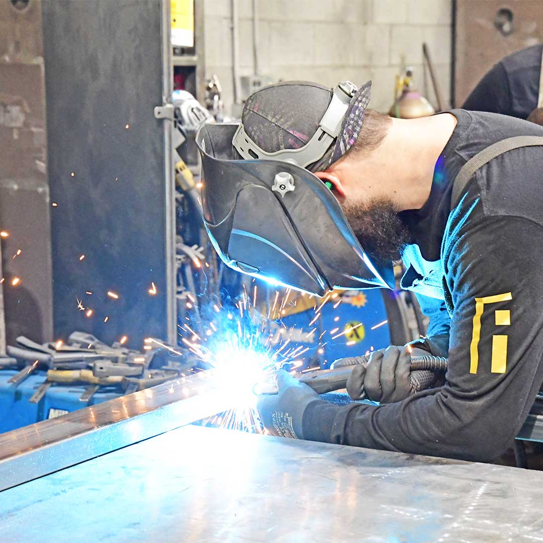 First Impression Ironworks employee welding an iron door
