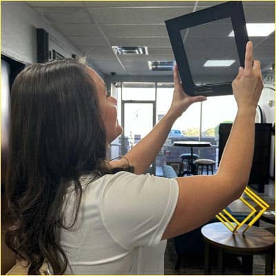 First Impression Ironworks employee holding up a HomeGuard Screen sample. showing that you can see through the screen