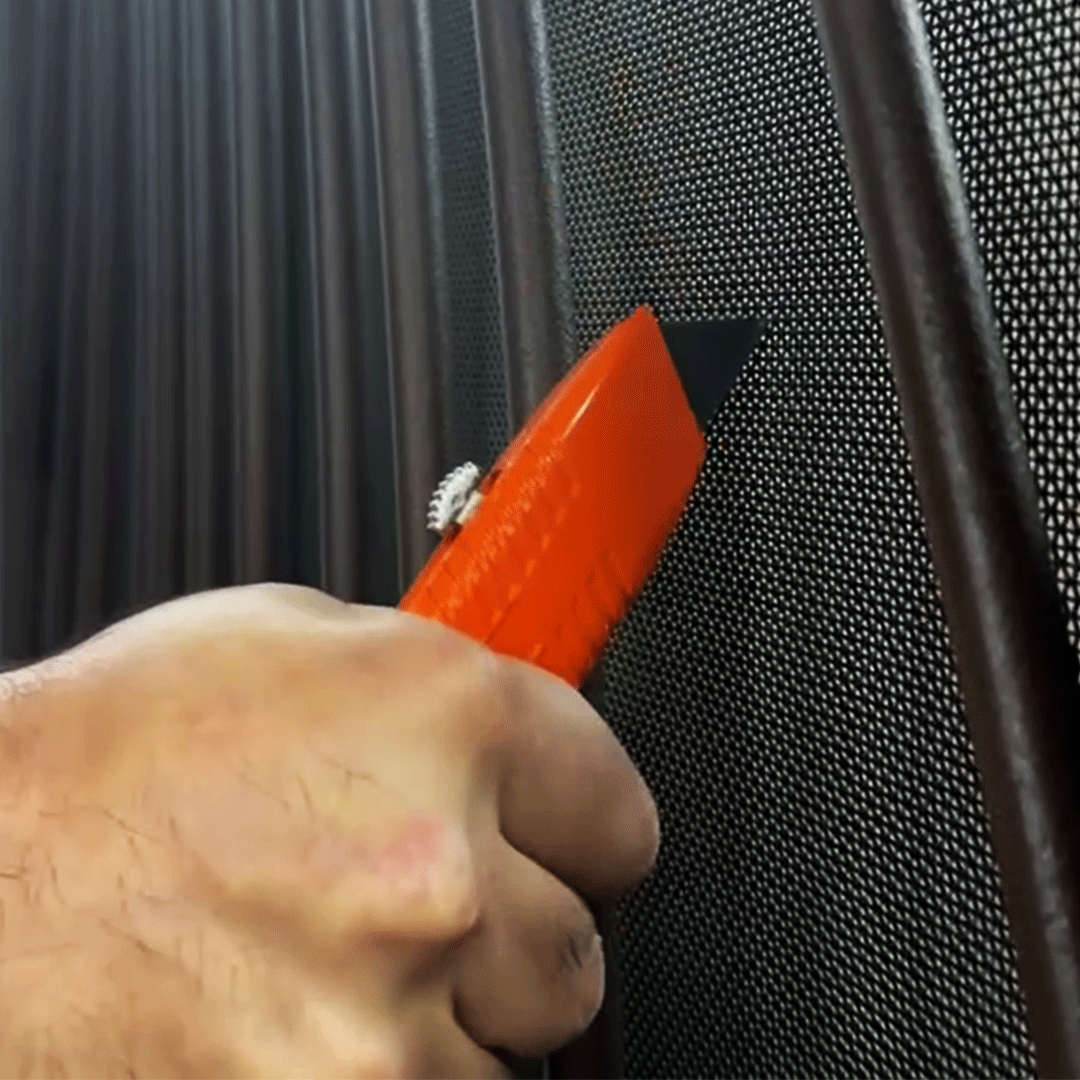 Hand using a box cutter to try and cur through a HomeGuard Security Screen