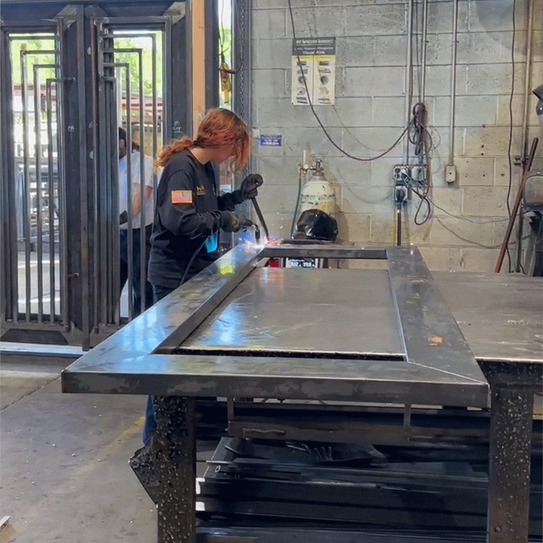 First Impression Ironworks welder working on the frame of a custom iron door