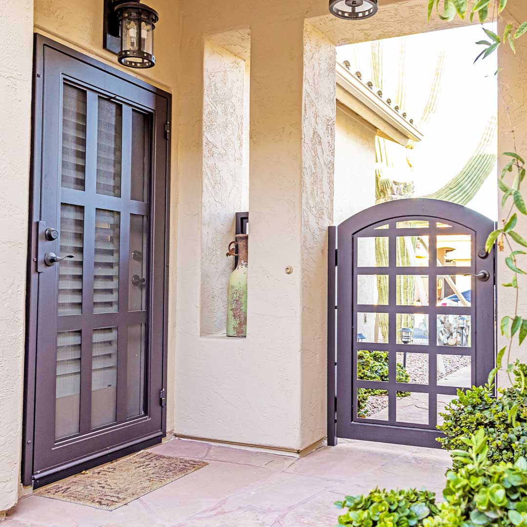 Entry of a home showing matching iron courtyard gate and iron security door