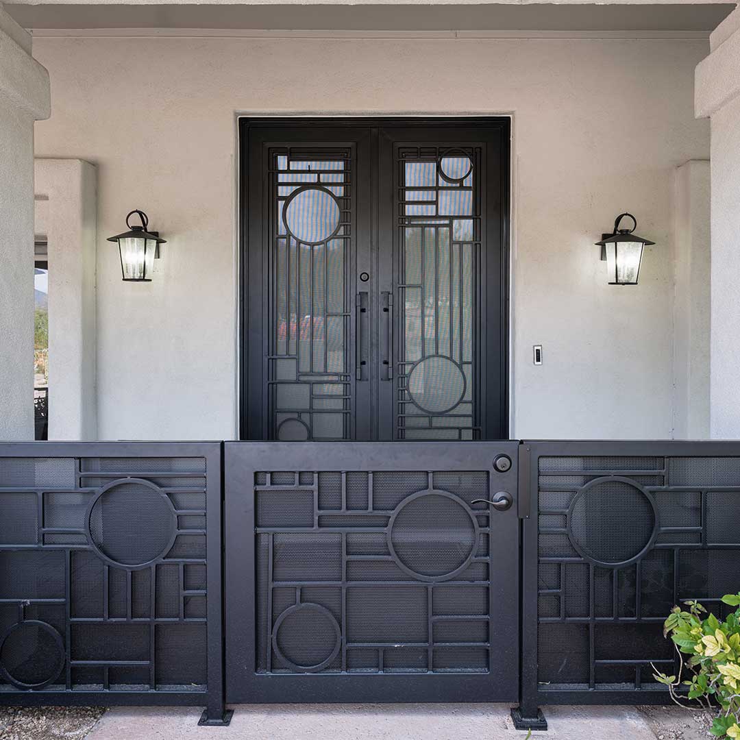 Entry of a home showing matching black iron courtyard gate and iron security door