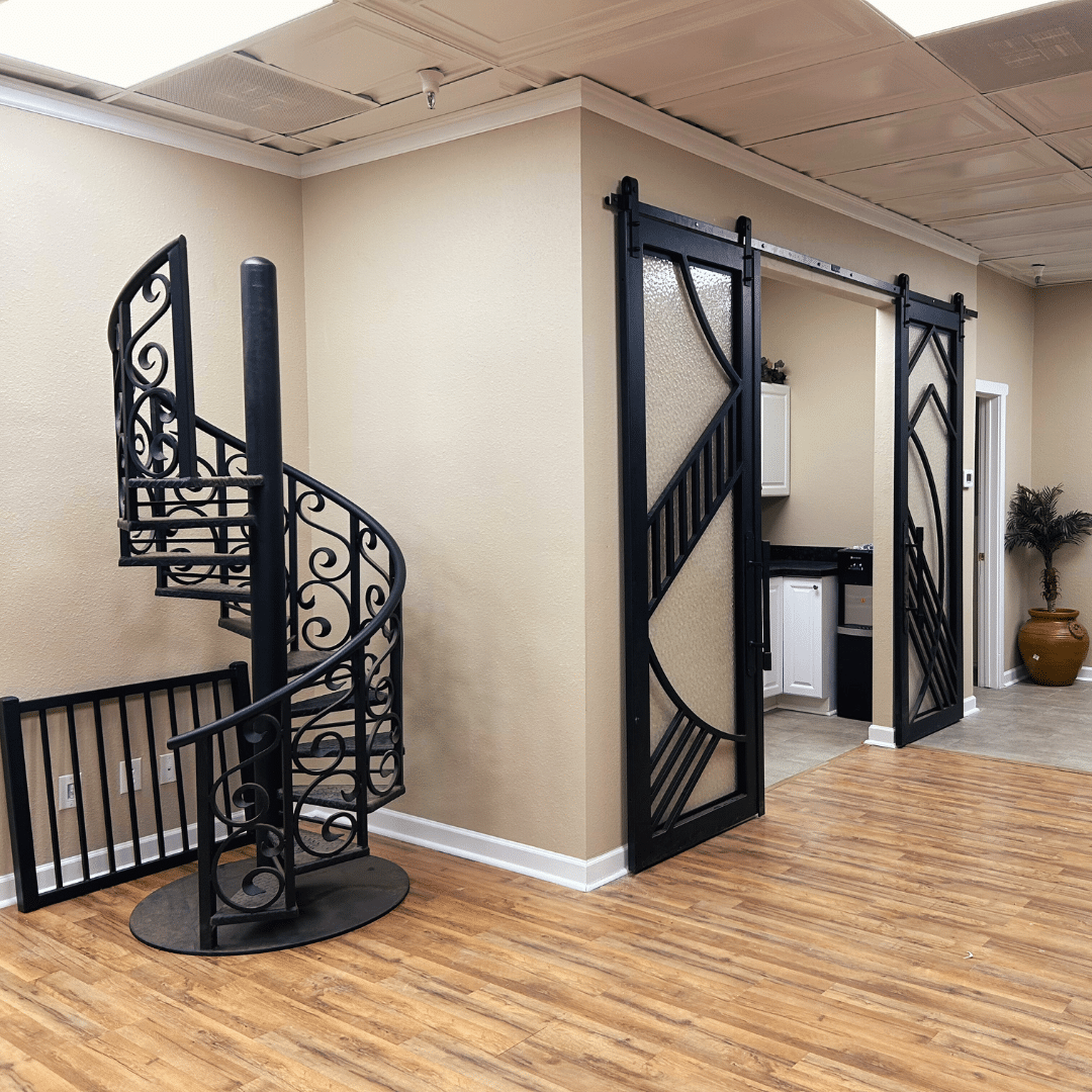 Display at the Scottsdale First Impression Ironworks showroom, displaying an iron spiral staircase and iron barn doors.