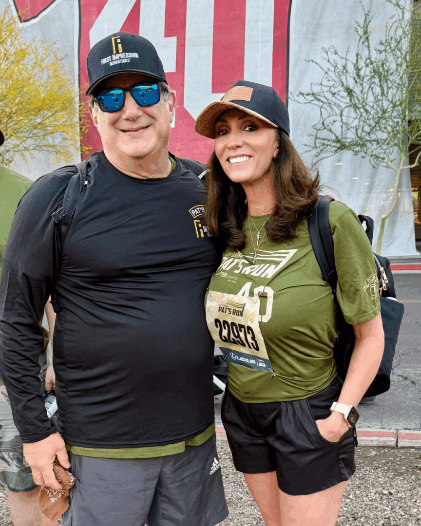 Two First Impression Ironworks employees, smiling at the camera at the Pat Tillman run