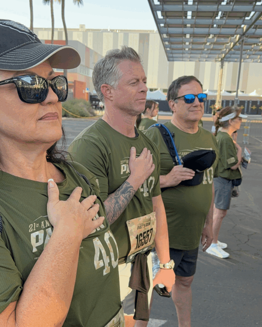 First Impression Ironworks team members with their hand over their hearts, to show respect, at the start of the Pat Tillman run