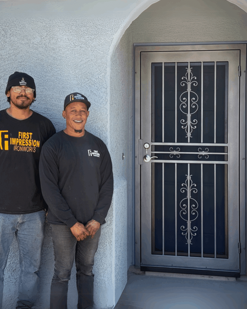 Two First Impression Ironworks team members posing for a picture with the fdoor that First Impression Ironworks donated to a single mother 