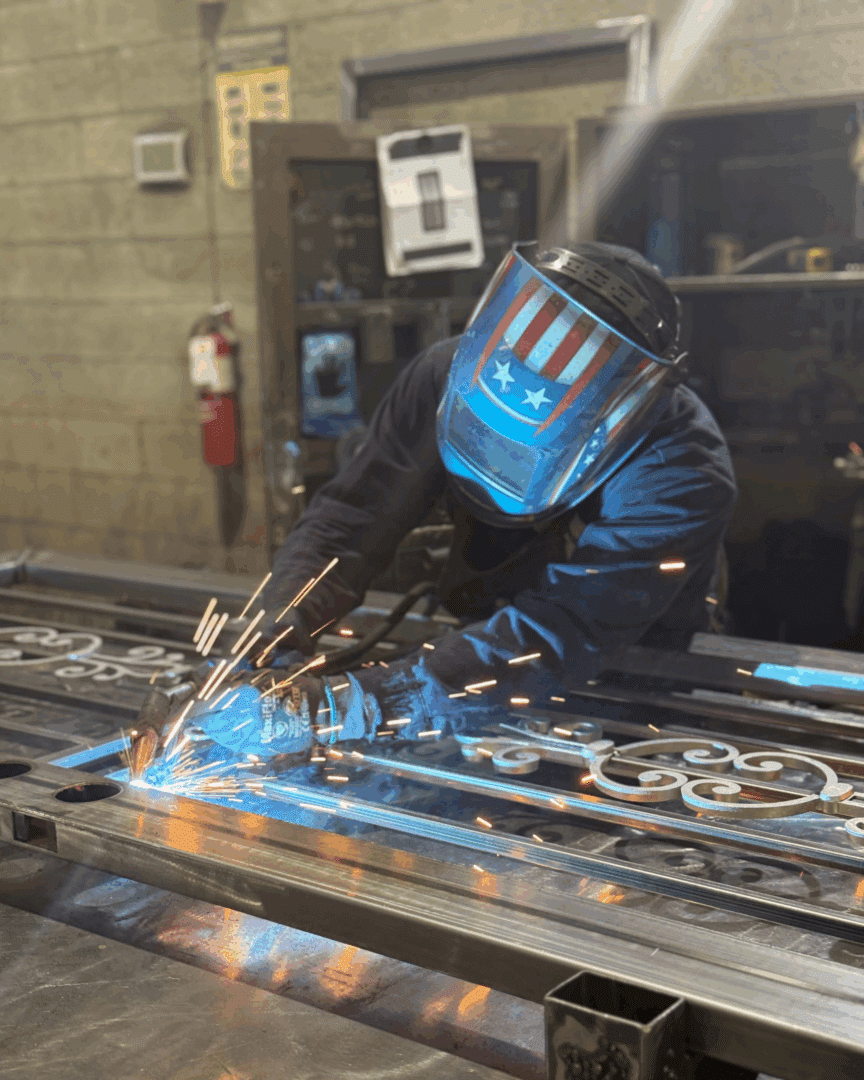 Welder working on the iron security door that was donated through Habitat for Humanity