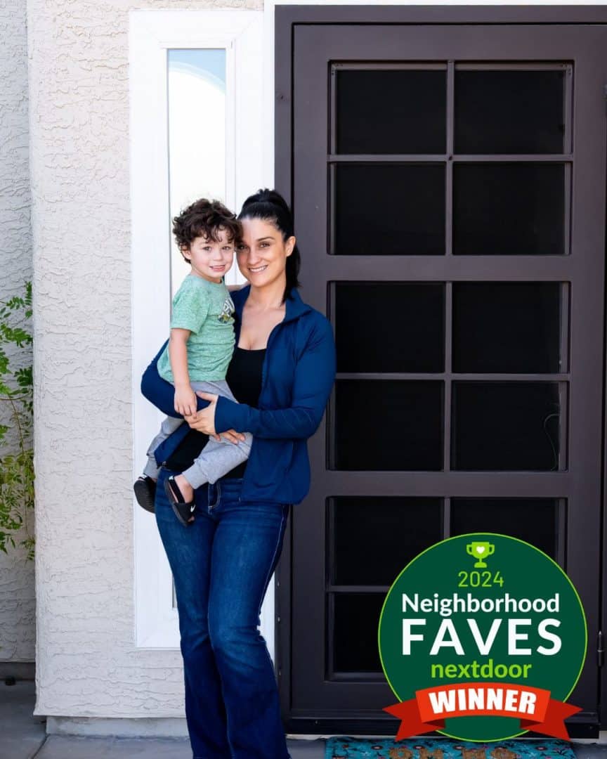 Woman and her son in smiling in front of their new First Impression Ironworks security door