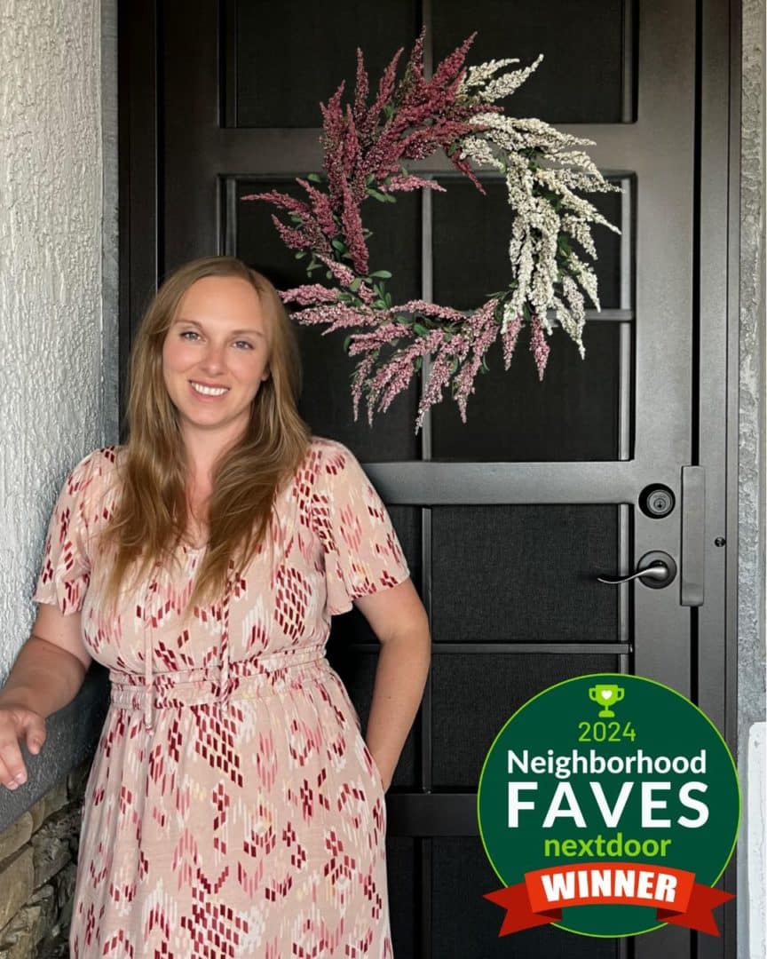 Smiling woman in front of her new First Impression Ironworks Security Door