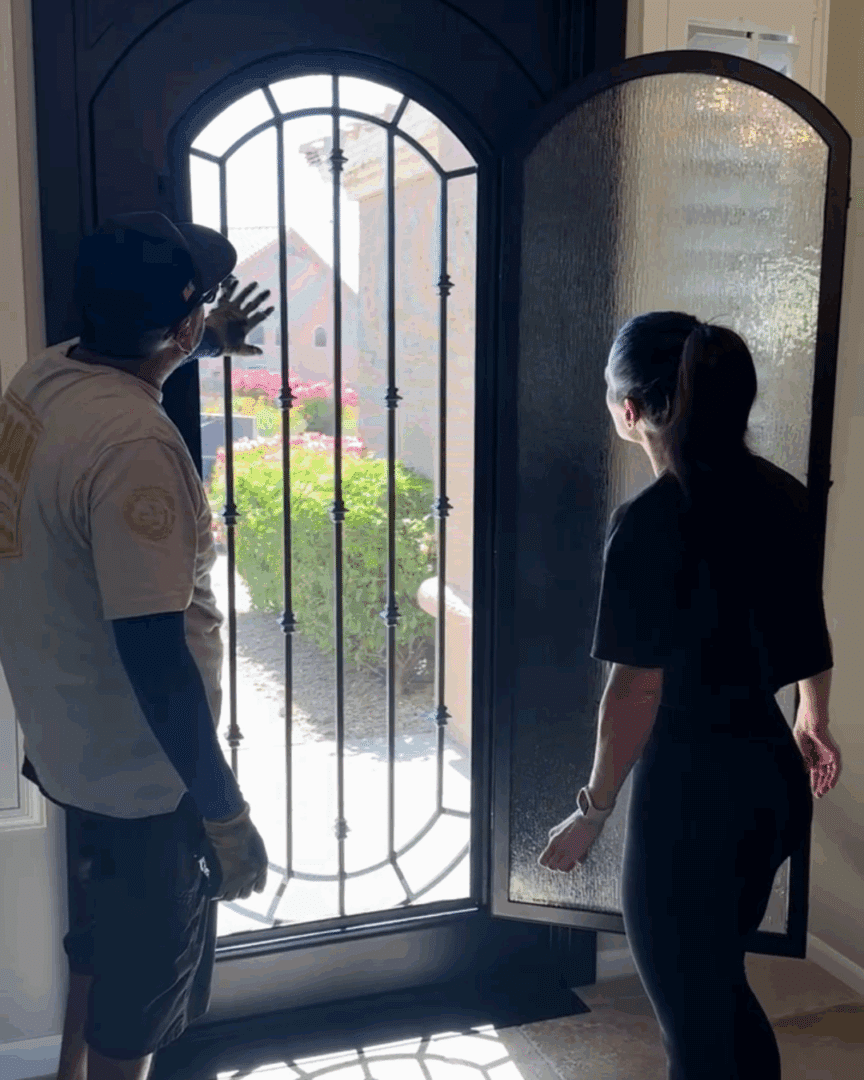 First Impression Ironworks employee showing a homeowner the feature of her new iron entry door