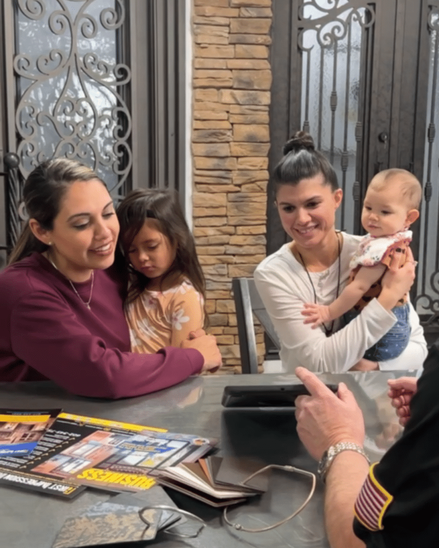 Neg, Mel and their children, sitting at a table, meeting with a First Impression Ironworks design specialist